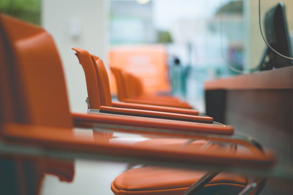 Close-up of sleek orange office chairs in a waiting area with focus on design.